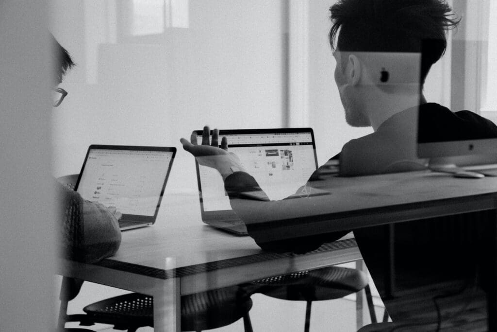 Two people talking with Laptops